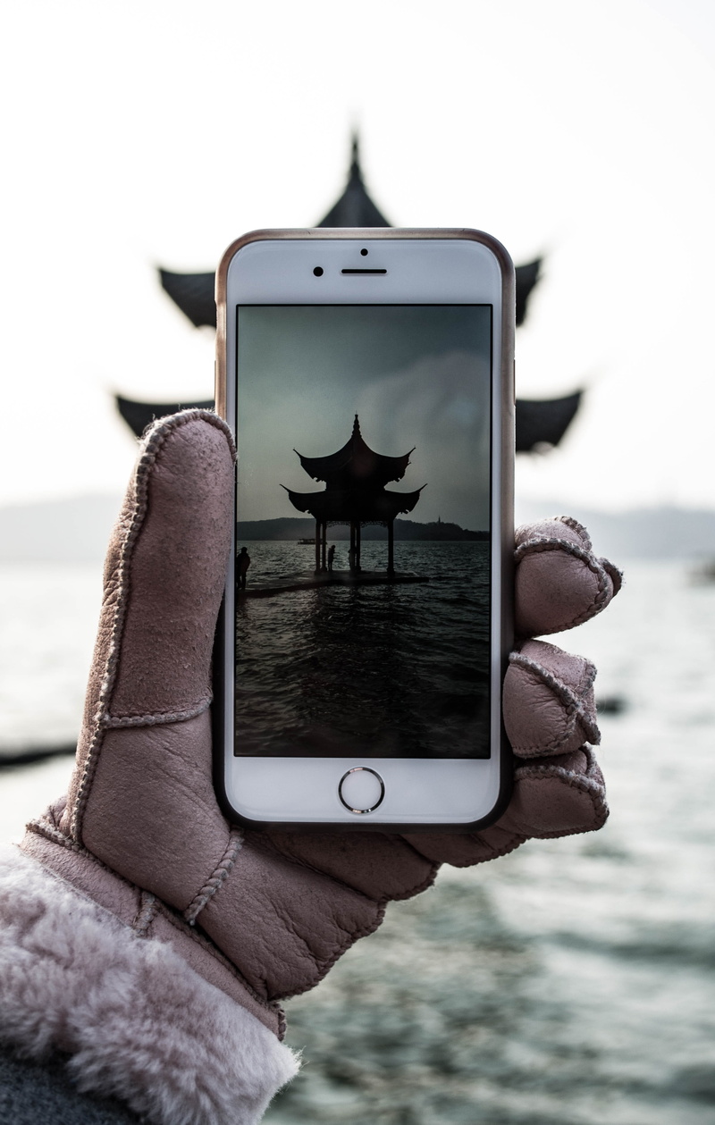 hangzhou, sunset, holding, outdoors, real people, iphone, sea, human body part, lake, human hand, technology, unrecognizable person, day, light, water