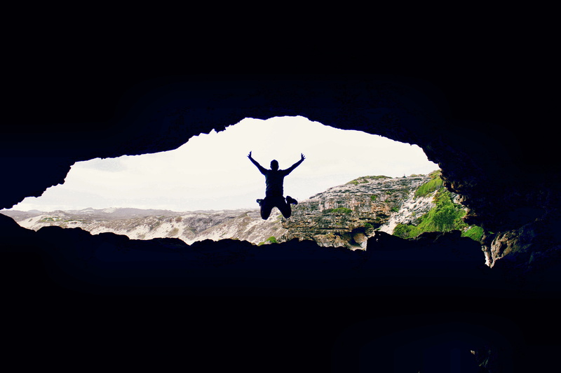 nature, one person, leisure activity, boulders, lifestyles, freedom, standing, cave, outdoors, rock formation, full length, explore, rocks, arms raised