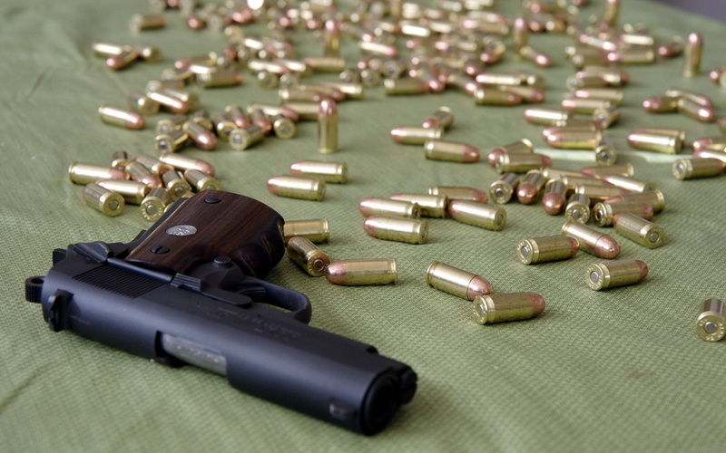 1080P, handgun, large group of objects, sign, table, Weapons, selective focus, close-up, communication, social issues, gun, ammunition, weapon, high angle view