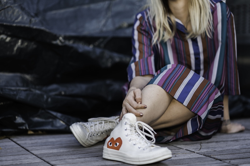 lifestyles, wood, young adult, day, body part, sitting, tire, 5K, one person, adult, fashion, childhood, running shoe, striped, hat, floor, casual clothing