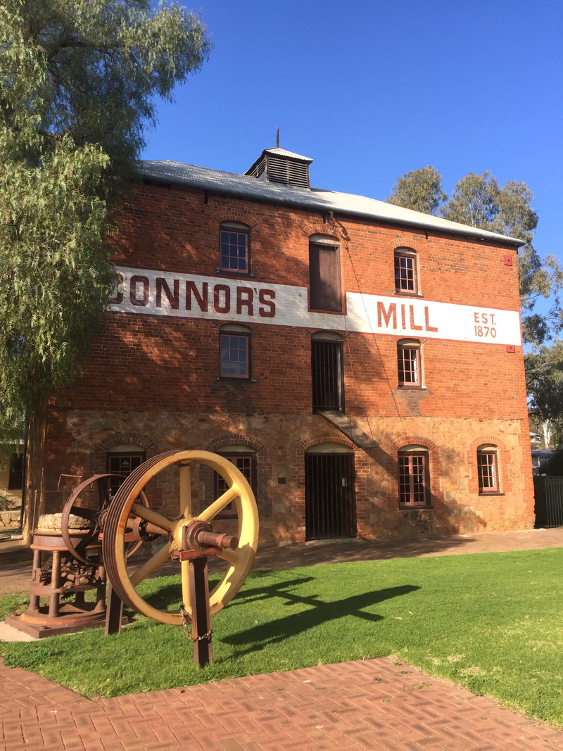 day, text, outdoors, lawn, vintage, mill, sky, history, historic, nature, built structure, building exterior, red, communication, growth, brick, western