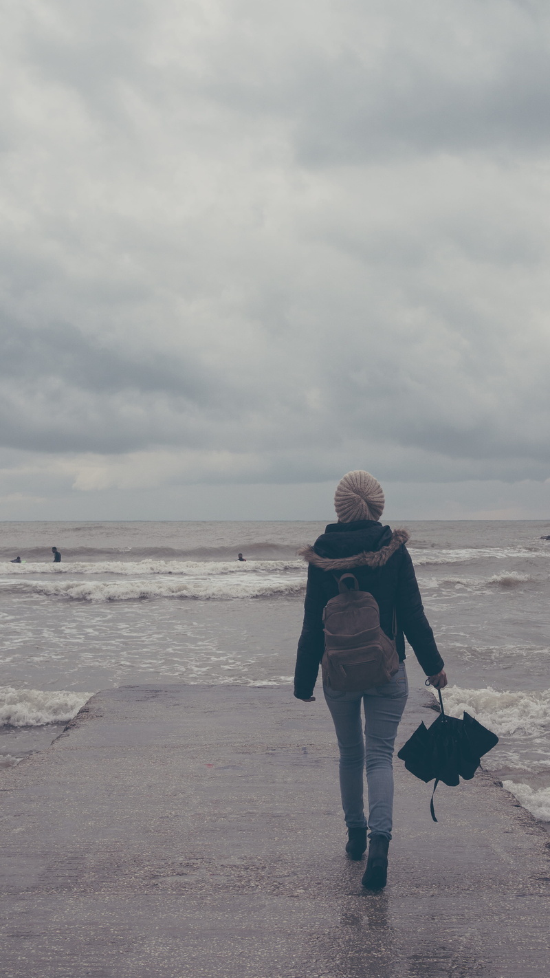outdoors, cloud - sky, real people, walking, warm clothing, one person, land, tel aviv, clouds, israel, beauty in nature, horizon over water, leisure activity