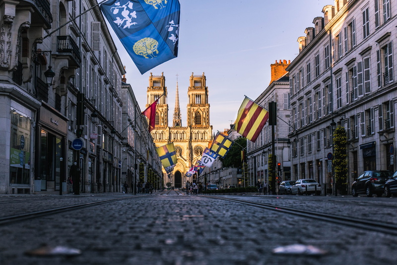 city street, flag, cathedral, road, the way forward, building exterior, day, incidental people, flags, france, rue jeanne darc, sky, building, street, built structure