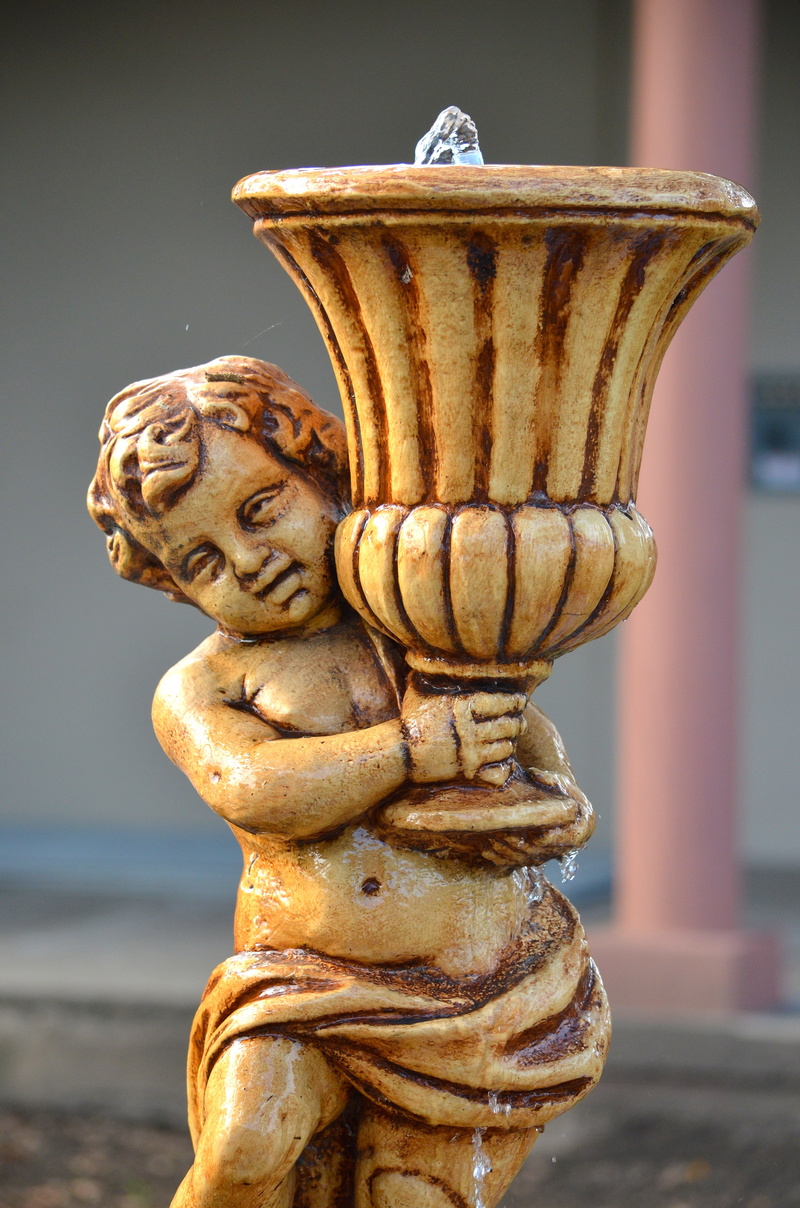 fountain, outdoors, close-up, craft, human representation, representation, focus on foreground, no people, gold colored, rusty, creativity, sculpture, statue