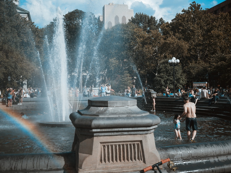 incidental people, splashing, group of people, large group of people, teal, building exterior, spraying, rainbow, new york, architecture, flowing water