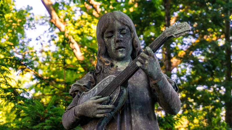 woman, holding, girl, male likeness, gray, concrete, tree, close-up, leafed, art, focus on foreground, stature, statue, day, green, playing, person, outdoors
