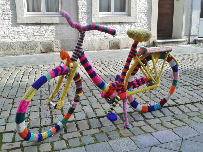 multi colored, outdoors, commuters, artwork, action, shape, large group of objects, built structure, footpath, metal, road, bicycles, funny, multicolored