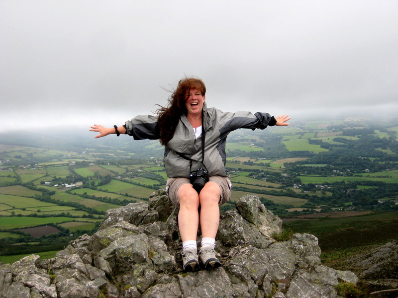 landscape, limb, full length, peak, freedom, hair, sitting, open arms, beauty in nature, rock - object, emotion, women, rock, young adult, woman, beautiful woman