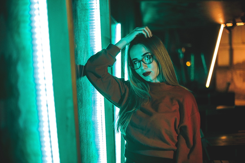 light, woman, 5K, night life, long sleeve, wall, young adult, front view, human, leaning, clothing, indoors, hand, looking at camera, display, holding