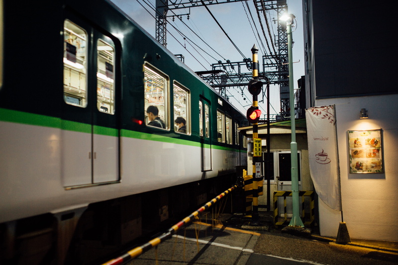lighting equipment, architecture, railroad station platform, tarmac, neighborhood, passenger train, black, electricity, railroad track, human, built structure