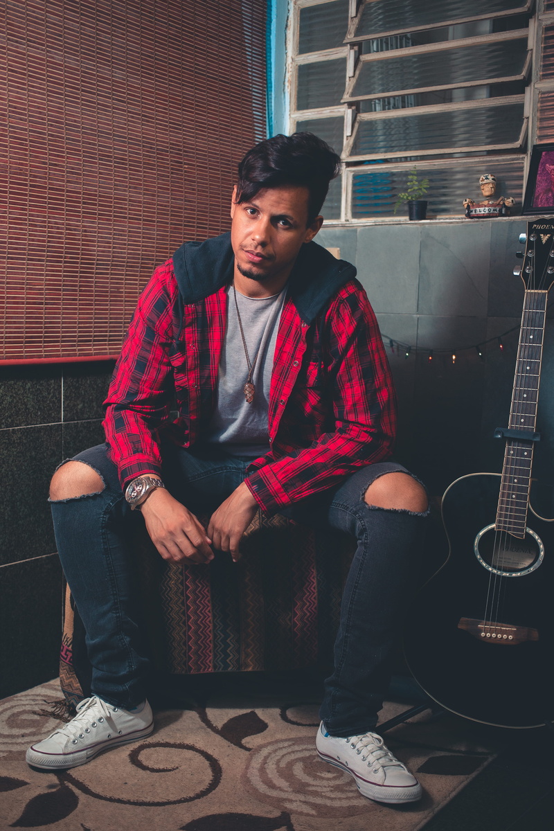 5K, arts culture and entertainment, brick, portrait, architecture, sitting, musician, adult, indoors, relaxation, front view, guitar, jacket, person, full length