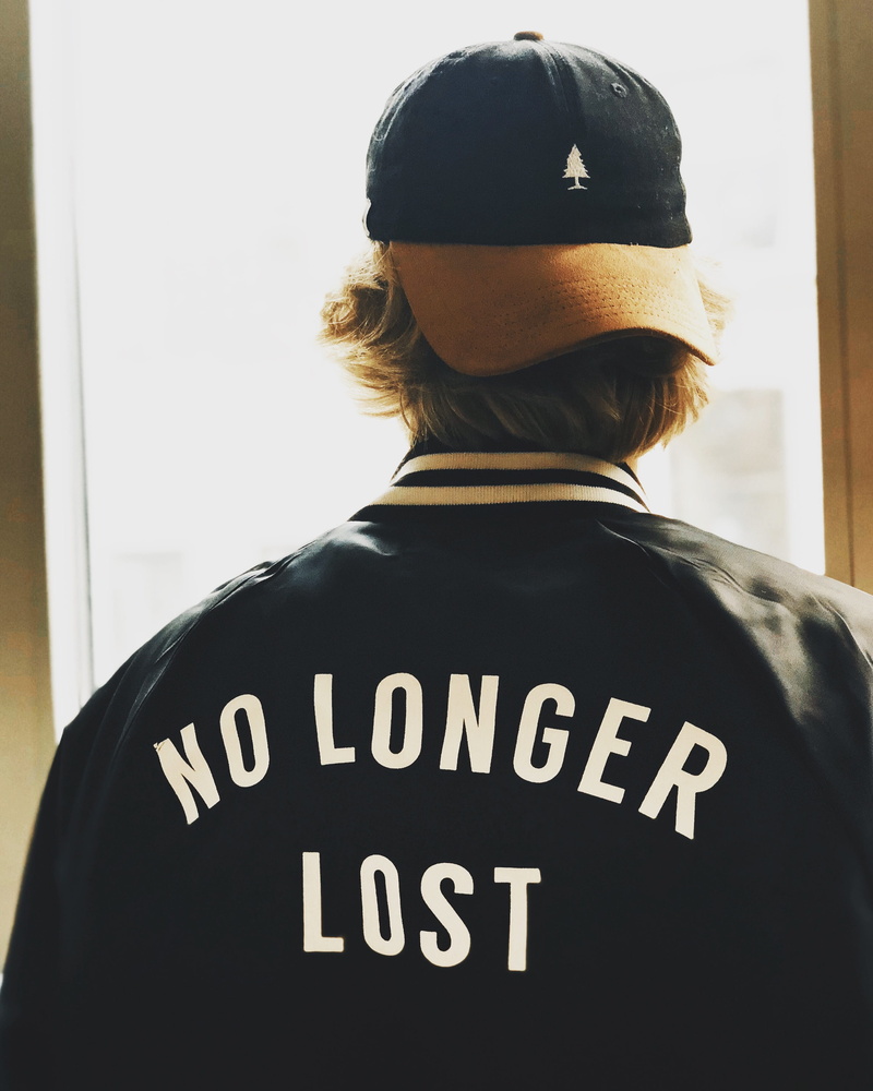 male, jacket, letterman, real people, waist up, t-shirt, lifestyles, leisure activity, man, western script, not lost, black, lost, window, cap, portrait