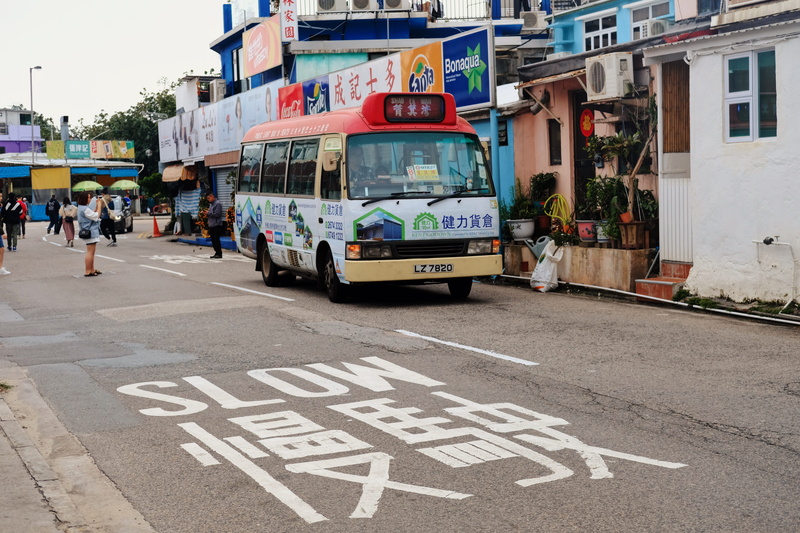 group of people, person, city street, bus, zebra crossing, street, mode of transportation, incidental people, built structure, road, building, building exterior
