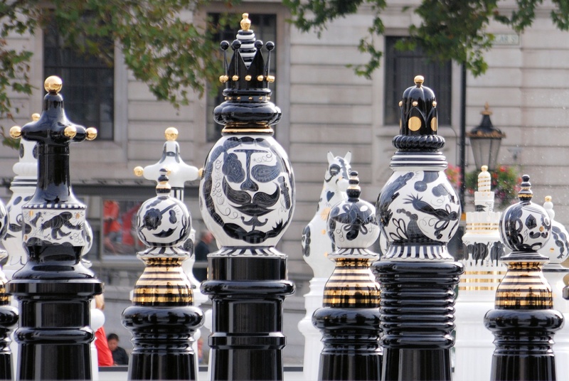 outdoors, sculpture, place of worship, chessboard, ornate, built structure, large group of objects, chess, intelligence, day, decors, focus on foreground