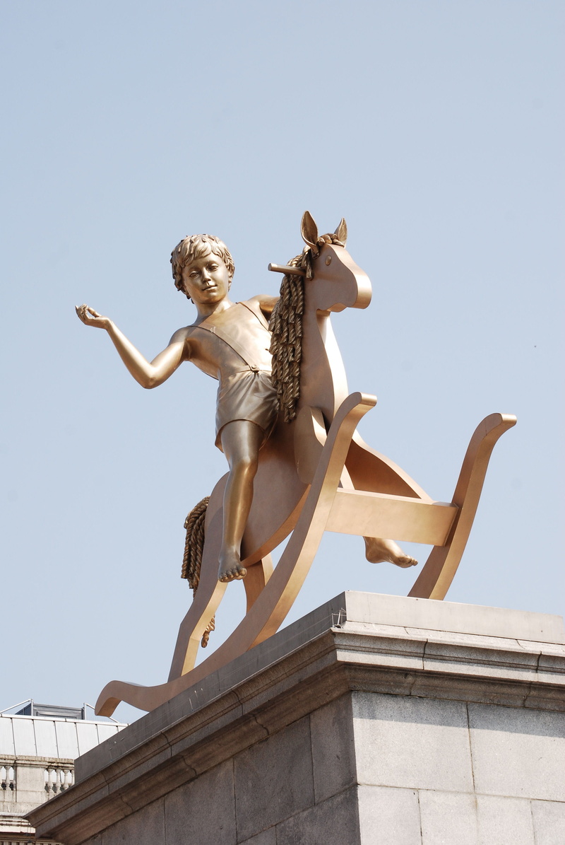 Sculpture, sunlight, outdoors, representation, Child, architecture, building exterior, nature, statue, human representation, creativity, day, square, Rocking Horse