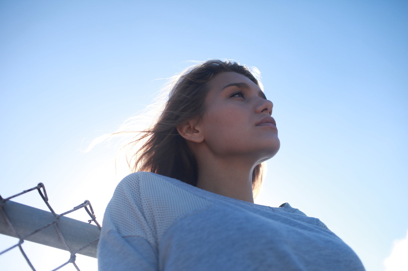 looking into the distance, contemplation, real people, outdoors, women, lifestyles, one person, sweatshirts, headshot, lens flare, women outdoors, leisure activity