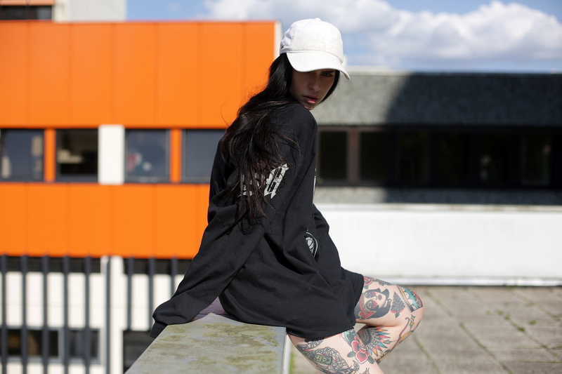 sweatshirts, built structure, architecture, inked girls, model, tattoo, women outdoors, one person, day, black color, clothing, lifestyles, sitting, leisure activity