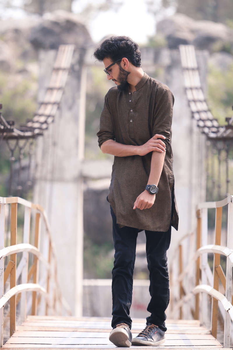 bridge, glasses, real people, young adult, architecture, outdoors, standing, man, day, focus on foreground, nature, posing, hairstyle, blurry background
