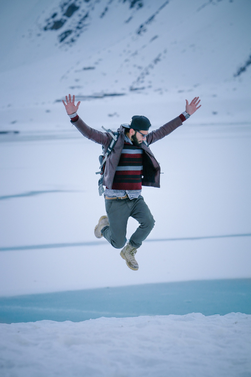 real people, limb, jumping, winter, arms raised, young, cap, fashion, pose, portrait, arms outstretched, boy, excitement, enjoyment, full length, adult