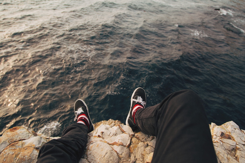 pants, outdoors, body part, pant, leg, human body part, feet, solid, ocean, two people, shoe lace, sitting, hang, real people, coast, low section, men