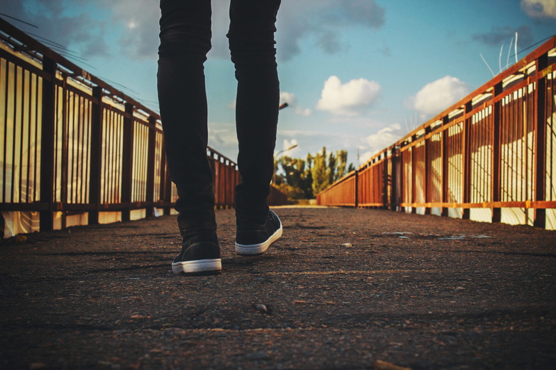 shoe, real people, low section, outdoors, casual clothing, sky, railing, leisure activity, shoes, human limb, day, bridge, surface level, walking, railings