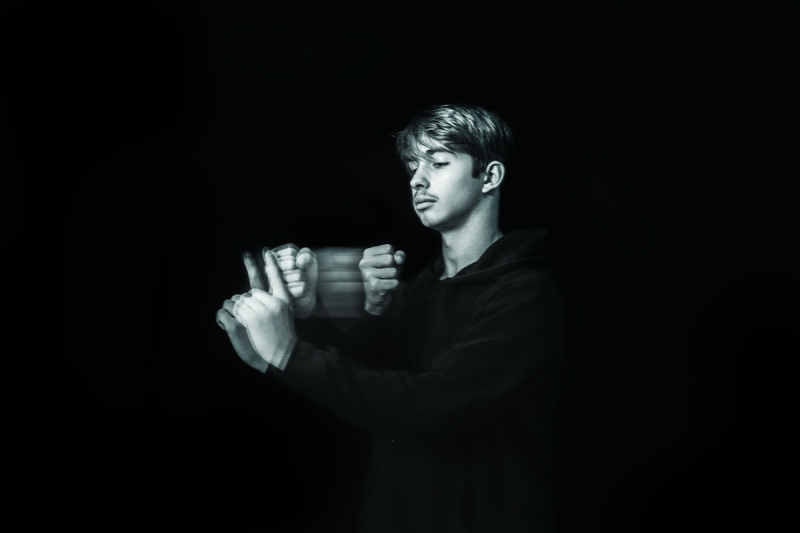 black color, holding, person, hand, long sleeve, sport, contemplation, portrait, man, people, dark, pullover, studio shot, communication, men, jaw, thumbs up