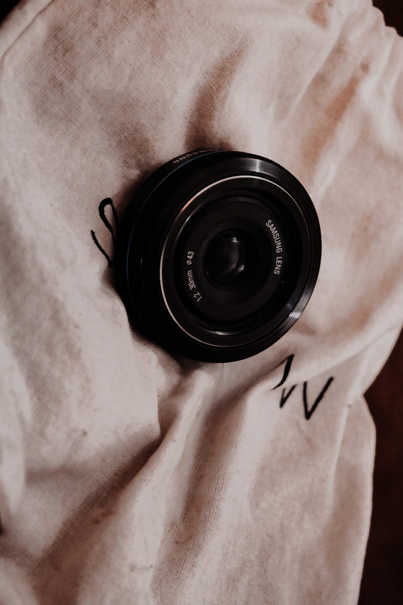 tote bag, camera, day, high angle view, communication, pen, midsection, photographer, home decor, lens cap, person, bag, tattoo, camera lens, 5K, indoors