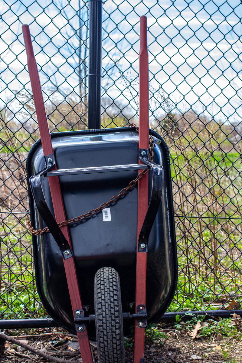 chainlink fence, machine, grass, safety, outdoors, tennis racket, fence, watercraft, wagon, theme park, mode of transportation, vessel, vehicle, plant