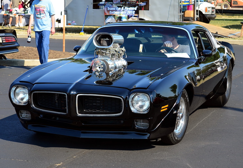 real people, one person, retro styled, street, 1975 Pontiac Firebird, stationary, day, standing, headlight, car, motor vehicle, incidental people, road