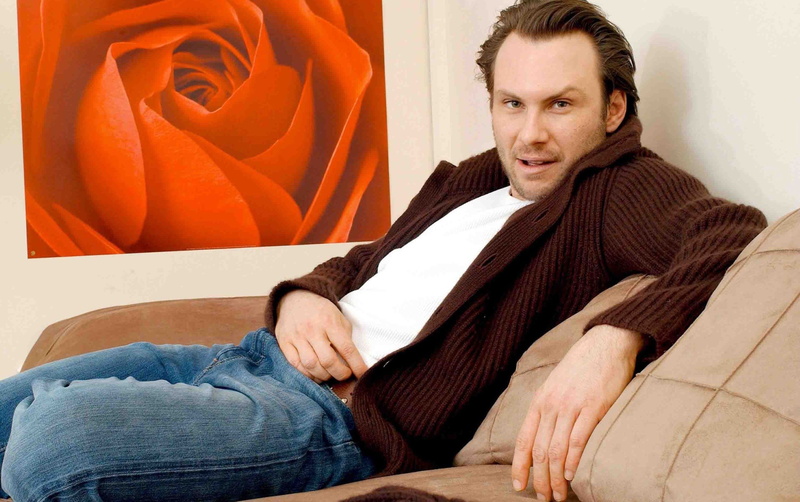 hairstyle, Christian slater, leisure activity, Jeans, lifestyles, smiling, relaxation, 2K, sofa, three quarter length, adult, contemplation, scarf, one person