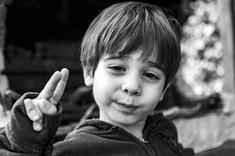 human face, looking at camera, sign, outdoors, hairstyle, innocence, focus on foreground, happiness, child, portrait, hulki okan tabak, bangs, nature, game