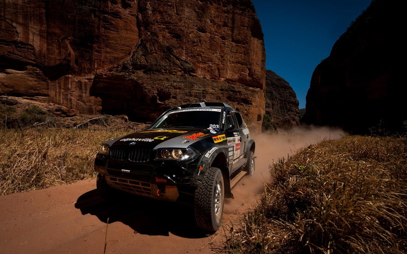 sunlight, formation, rock - object, off-road vehicle, land, dirt road, black, car, mountain, red, outdoors, sports, land vehicle, BMW, day, transportation
