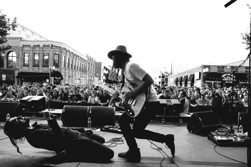 arts culture and entertainment, front, two, architecture, stage, day, sky, guitars, crowd, band, full length, daytime, playing, lefty, music, grayscale
