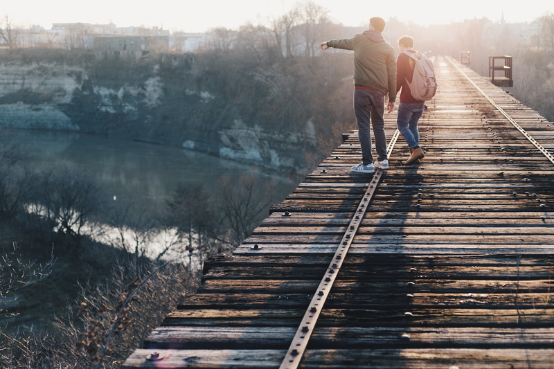 track, full length, wooden, railway, water, couple - relationship, looking, walking, two people, guy, real people, guys, women, daytime, two, pointing