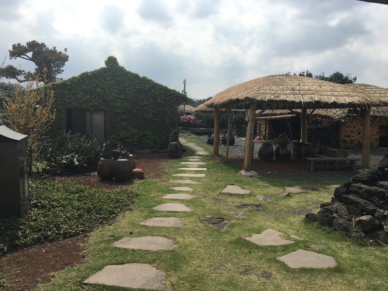 footpath, architecture, direction, cloud - sky, the way forward, religion, stone, plant, solid, grass, jeju island, traditional houses, building exterior