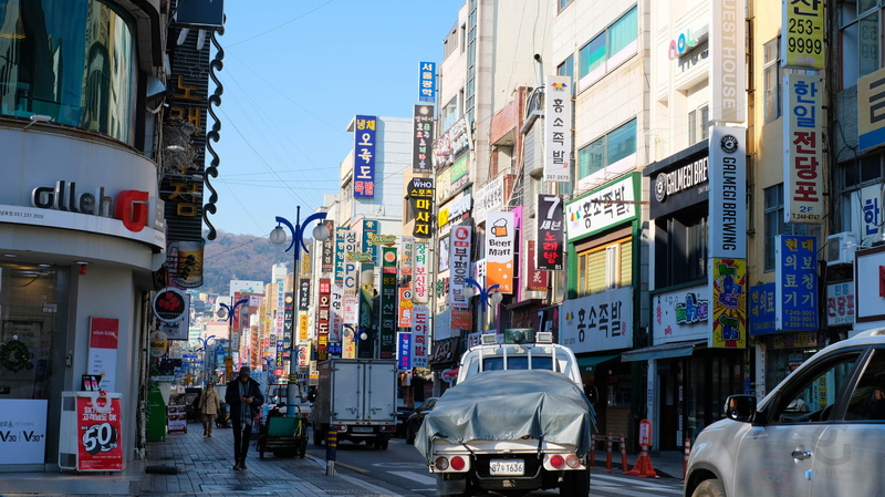 office building exterior, advertisement, incidental people, mode of transportation, city, architecture, car, building exterior, road, busan, built structure