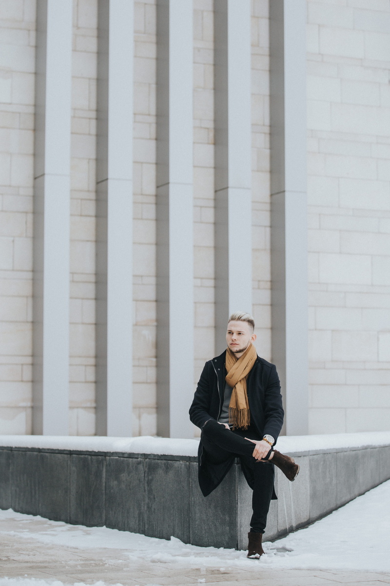 jacket, concrete, one person, architectural column, lifestyles, sitting, full length, casual clothing, suit, built structure, woman, outdoors, fashion