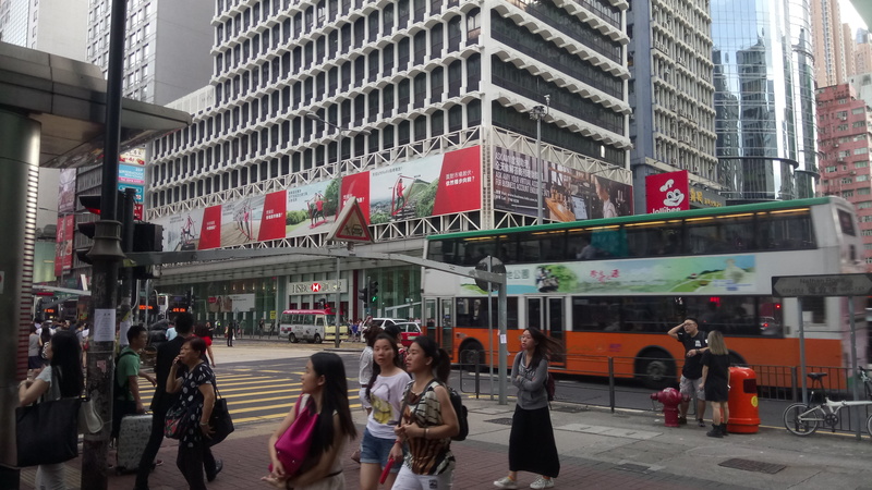 real people, office building exterior, street, outdoors, adult, built structure, city, city street, skyscraper, urban, text, city life, crowd, walking