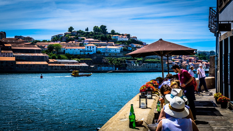 river, building exterior, eat, nature, sitting, wearing, city, distance, outdoors, travel destinations, portugal, go away, travel, concrete, women, boot