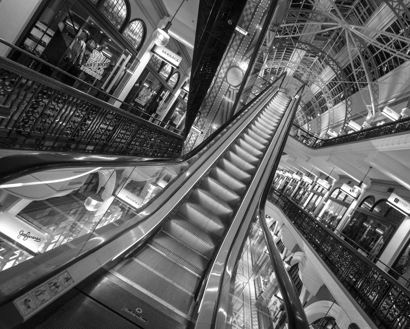 steps and staircases, indoors, railing, glass - material, incidental people, built structure, elevator, 4K, high angle view, monochrome, architecture