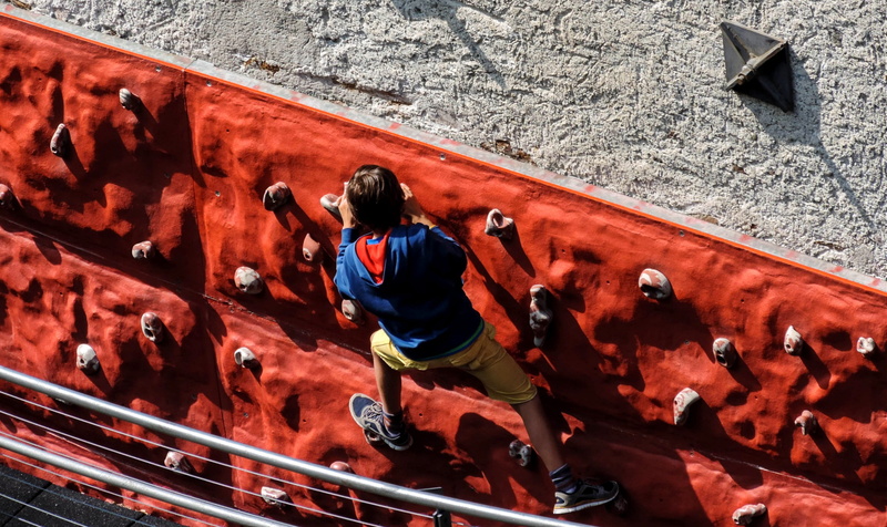 one person, built structure, architecture, red, fun, game, rope, lifestyles, rock climbing, men, full length, child, sport, outdoors, climbing, hung, occupation