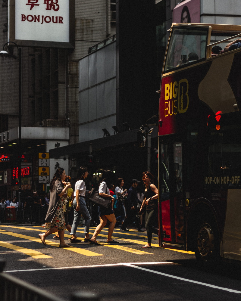 building exterior, hong kong, motion, communication, outdoors, fire truck, human, city street, text, road marking, black, crossing, road, city, china, bus