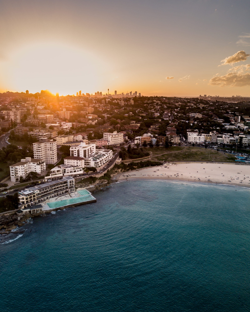 beach, sunset, built structure, sea, waterfront, landscape, building exterior, angle, body, trees, buildings, high angle view, near, water, no people, residential district