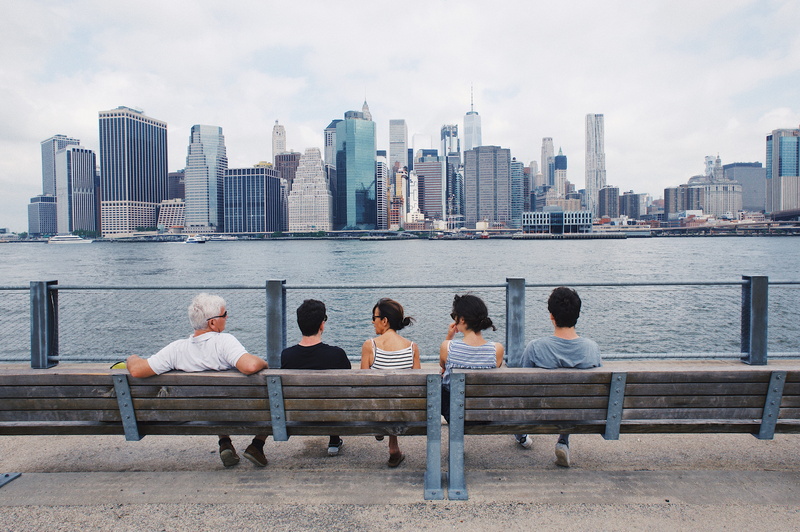 new york, seat, women, tall - high, people, united states, building, water, men, office building exterior, brooklyn bridge park, city, lifestyles, rear view