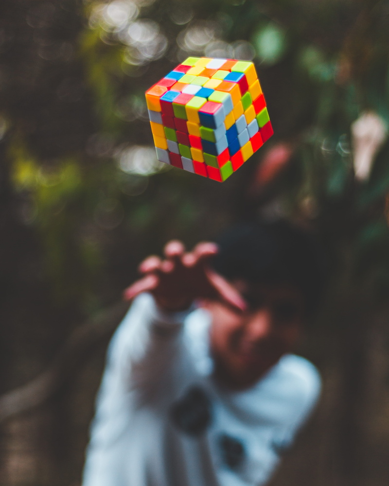 people, photo, one person, holding, hand, leisure activity, man, guy, outdoor, cube, human hand, human body part, men, depth, shallow, lifestyles, rubiks cube