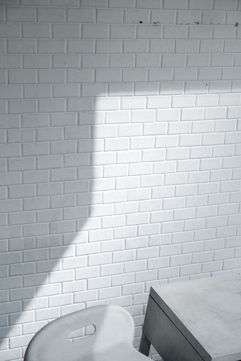 white, near, empty, wall - building feature, seat, no people, cement, still life, black-and-white, absence, brick wall, room, flooring, minimalism, architecture