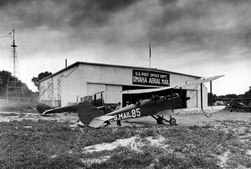 1940s, airplain, land, sky, architecture, nature, damaged, communication, text, hangar, building exterior, cloud - sky, airfield, sign, omaha, outdoors