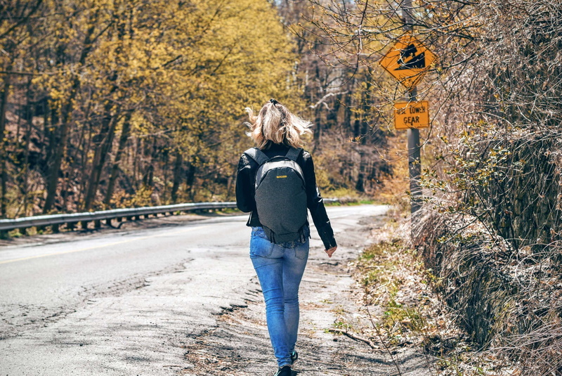 standing, real people, trees, women, young women, female, signs, hiker, road, lifestyles, walking, traffic signs, model, blonde, nature, tree, asphalt