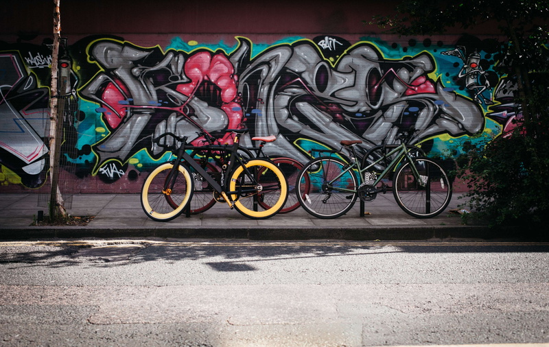 parked, pavement, no people, sidewalk, bicycles, creative, plant, parking lot, wall - building feature, mode of transportation, transportation, day, wall