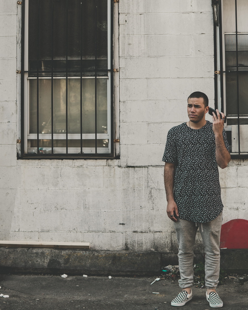 full length, one person, phone, mobile phone, wall, building exterior, architecture, front, young men, ear, near, building, technology, portrait, bars